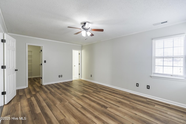 empty room with ceiling fan, dark wood-type flooring, ornamental molding, and a textured ceiling