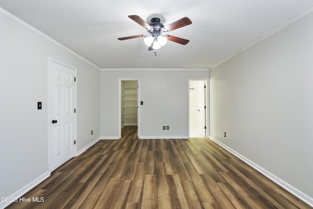 spare room featuring ornamental molding, dark wood-type flooring, ceiling fan, and a textured ceiling