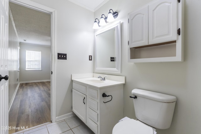 bathroom featuring crown molding, vanity, a textured ceiling, tile patterned floors, and toilet