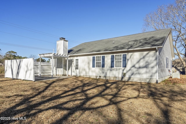 back of house with a lawn and a pergola