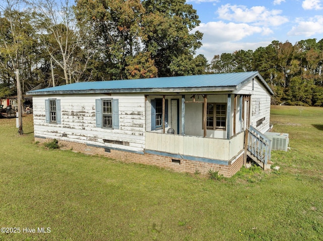 view of front of property with central AC and a front lawn