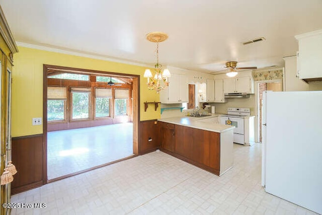 161 Willetts Dr, Boiling Spring Lakes, NC 28461 - kitchen with white appliances, a peninsula, a ceiling fan, a wainscoted wall, and light countertops