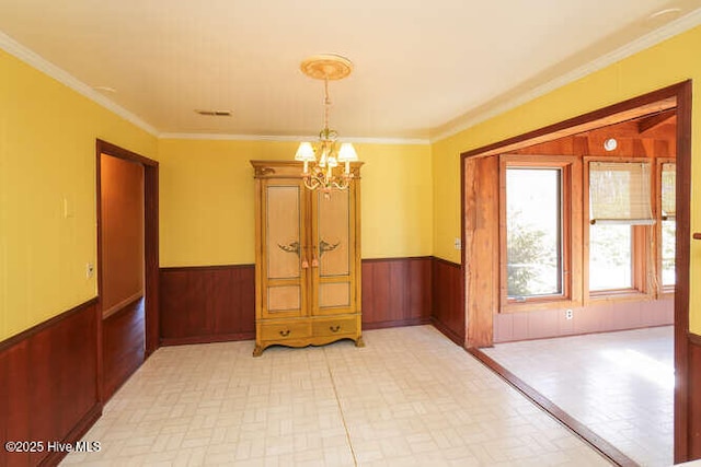 161 Willetts Dr, Boiling Spring Lakes, NC 28461 - unfurnished room with a chandelier, wainscoting, wood walls, and crown molding