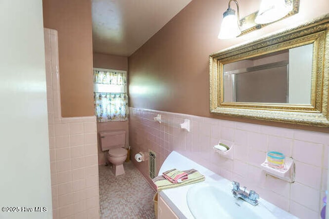 161 Willetts Dr, Boiling Spring Lakes, NC 28461 - bathroom with tile walls, toilet, a wainscoted wall, and vanity