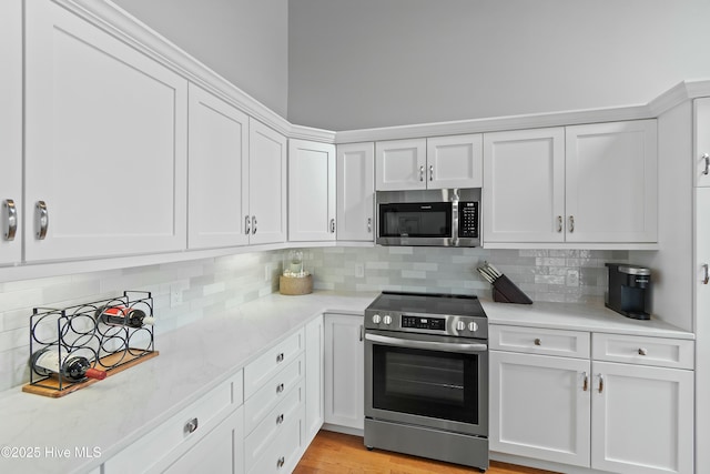 kitchen with white cabinetry, tasteful backsplash, and appliances with stainless steel finishes