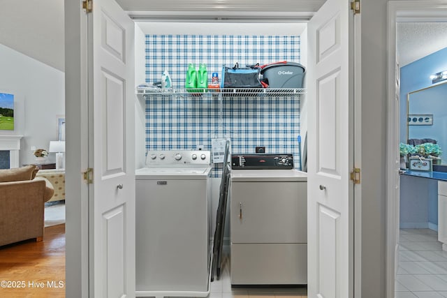 washroom with light tile patterned floors and washer and clothes dryer