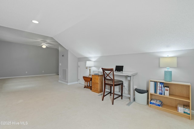 carpeted home office with ceiling fan and vaulted ceiling