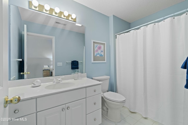 bathroom featuring tile patterned flooring, vanity, a textured ceiling, and toilet