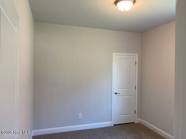 carpeted empty room featuring baseboards