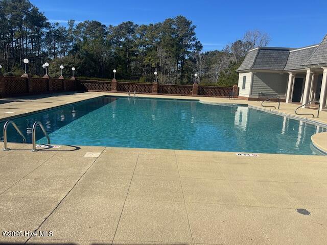 pool with fence and a patio