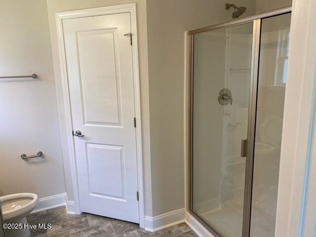 full bath with toilet, baseboards, and a stall shower