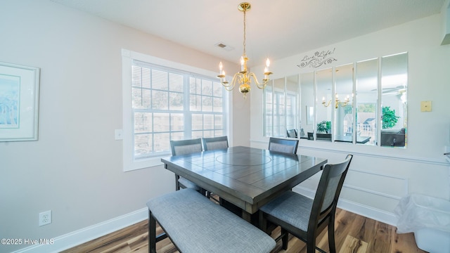 dining room with an inviting chandelier, wood-type flooring, and a healthy amount of sunlight