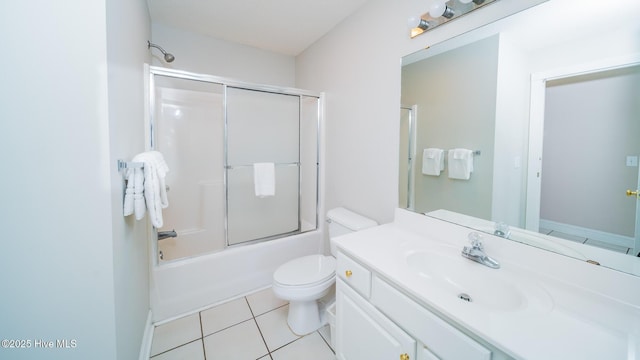 full bathroom featuring vanity, bath / shower combo with glass door, tile patterned floors, and toilet