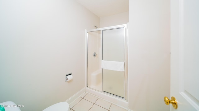 bathroom featuring tile patterned flooring, walk in shower, and toilet