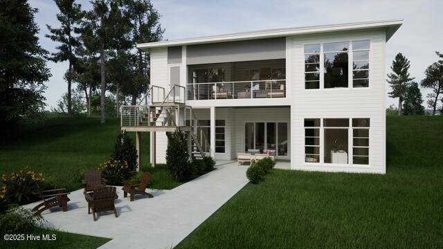 rear view of property with a yard, a fire pit, a patio, and a balcony