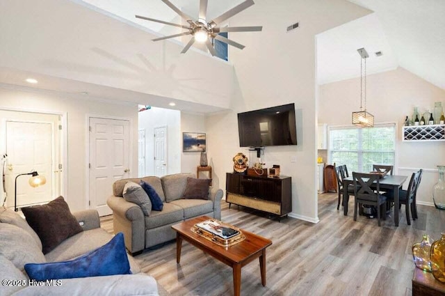 living room with hardwood / wood-style flooring, high vaulted ceiling, and ceiling fan