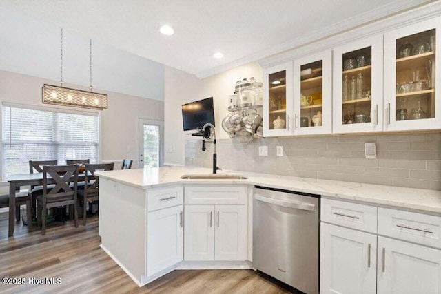 kitchen featuring dishwasher, white cabinetry, hanging light fixtures, decorative backsplash, and light wood-type flooring