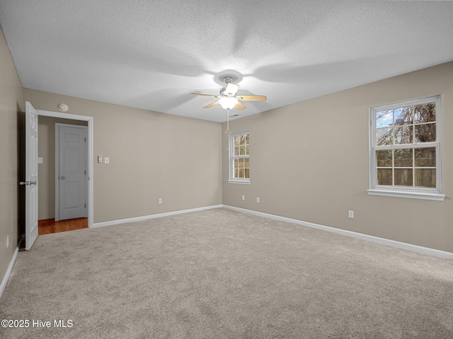 carpeted empty room featuring ceiling fan and a textured ceiling