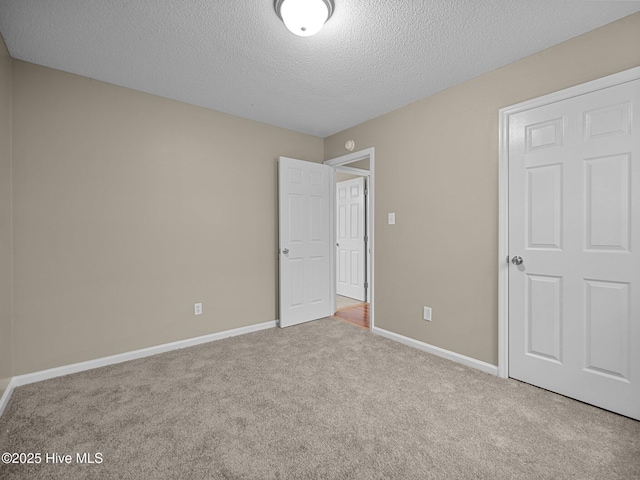 unfurnished bedroom featuring light carpet and a textured ceiling