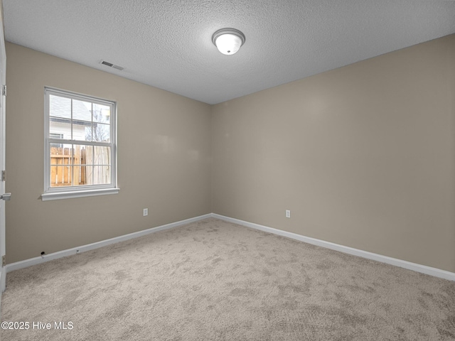 carpeted spare room with a textured ceiling