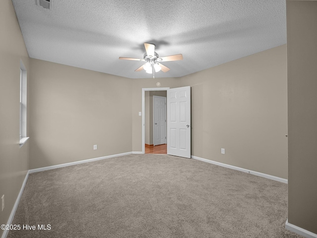 unfurnished bedroom featuring light carpet, ceiling fan, and a textured ceiling