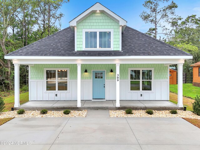 view of front of home with covered porch and a front lawn