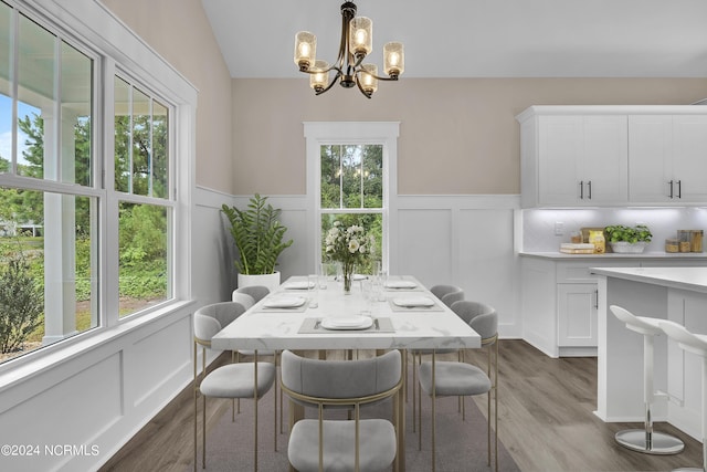 dining room with a wealth of natural light, an inviting chandelier, and dark wood-style floors