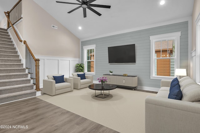 living area with wood finished floors, a ceiling fan, visible vents, recessed lighting, and stairs