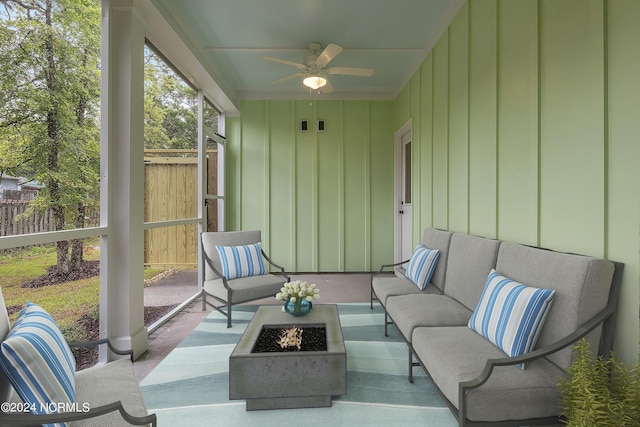 sunroom with a ceiling fan and an outdoor living space with a fire pit