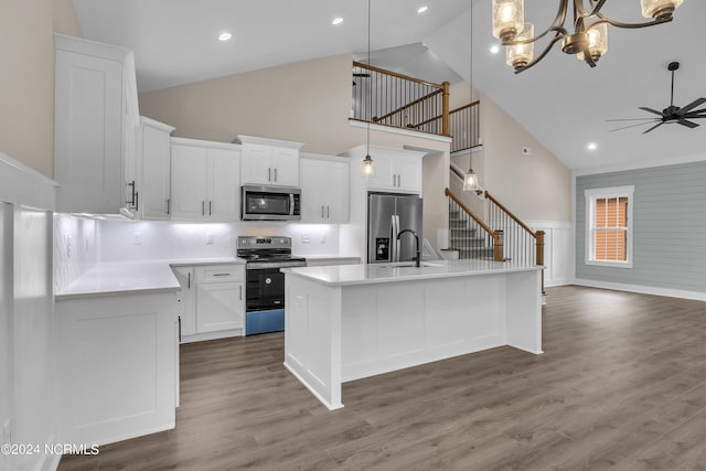 kitchen with light countertops, an island with sink, wood finished floors, and stainless steel appliances