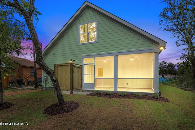 back house at dusk featuring a yard