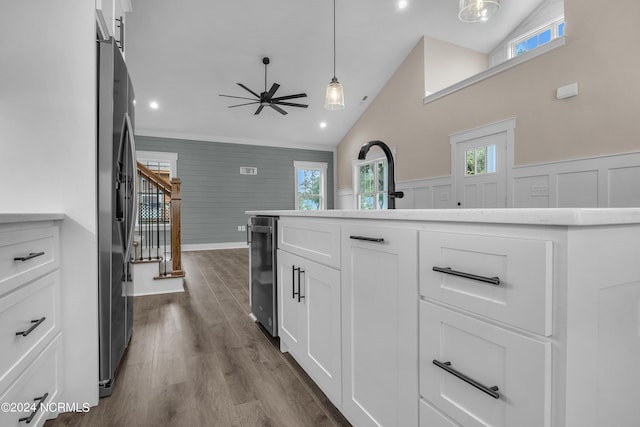 kitchen with a wainscoted wall, dark wood-type flooring, white cabinets, ceiling fan, and vaulted ceiling