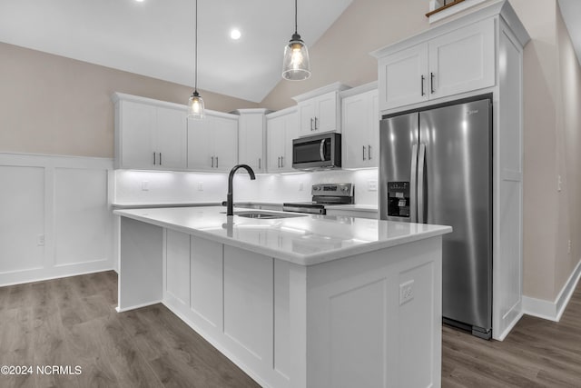 kitchen featuring an island with sink, a sink, white cabinetry, wood finished floors, and stainless steel appliances