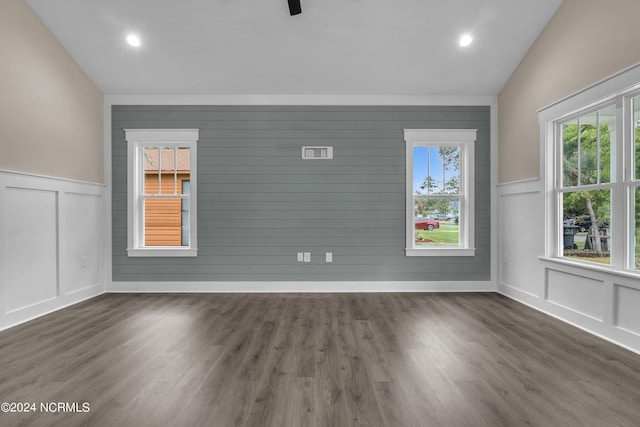 unfurnished room featuring dark wood finished floors and a decorative wall