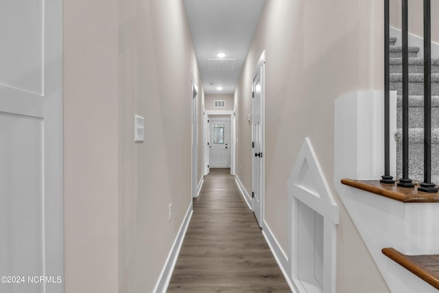 hall featuring baseboards, dark wood-style floors, and visible vents