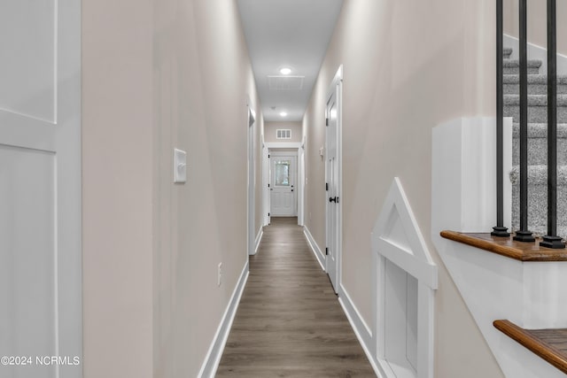 corridor featuring dark wood-style floors, visible vents, and baseboards