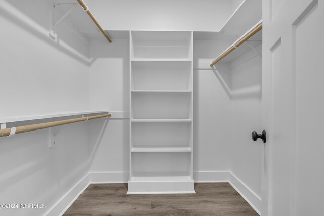 walk in closet with dark wood-type flooring