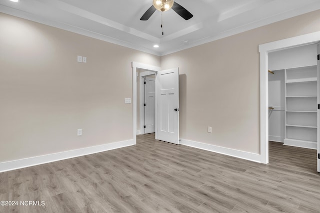 unfurnished bedroom featuring baseboards, light wood-style floors, and a spacious closet