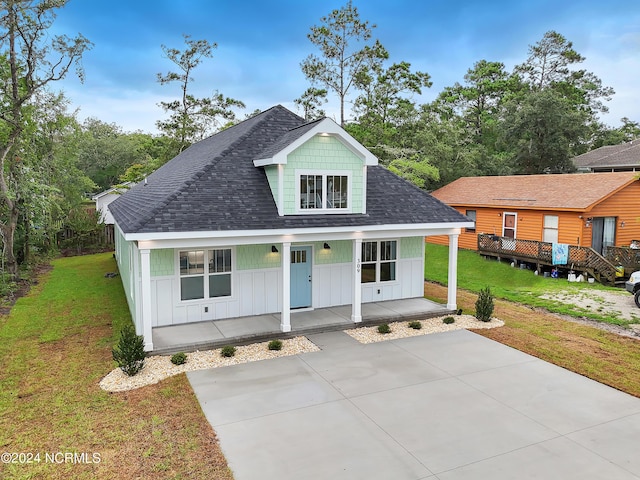 view of front of property with covered porch, board and batten siding, and a front yard