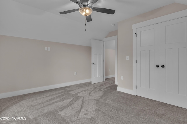 unfurnished bedroom with ceiling fan, baseboards, carpet, and lofted ceiling