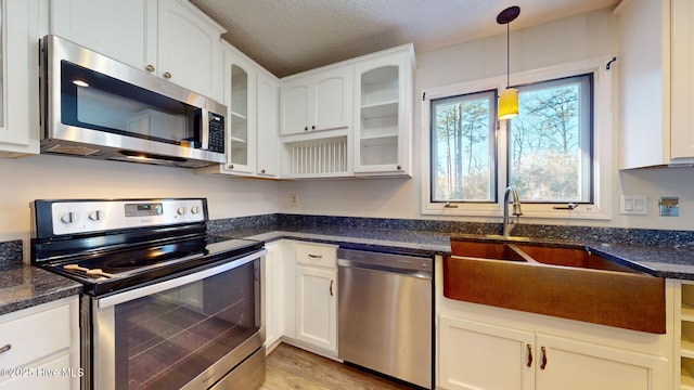 kitchen featuring appliances with stainless steel finishes, sink, white cabinets, and a textured ceiling