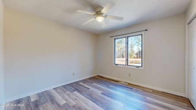 empty room featuring ceiling fan, a textured ceiling, and light hardwood / wood-style floors