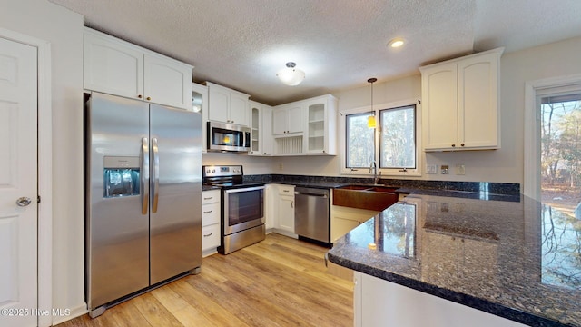 kitchen with white cabinetry, decorative light fixtures, plenty of natural light, and appliances with stainless steel finishes