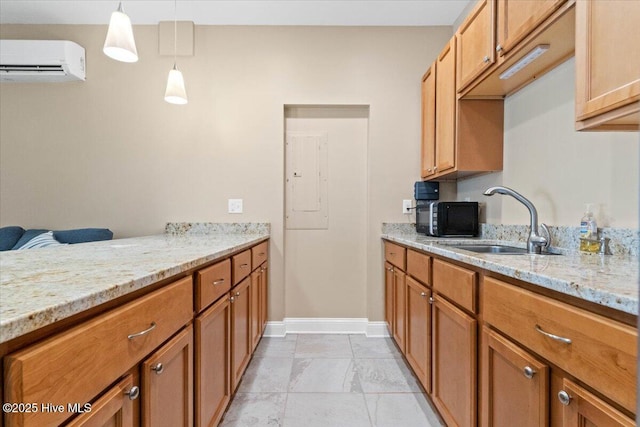 kitchen featuring decorative light fixtures, light stone countertops, sink, and a wall unit AC