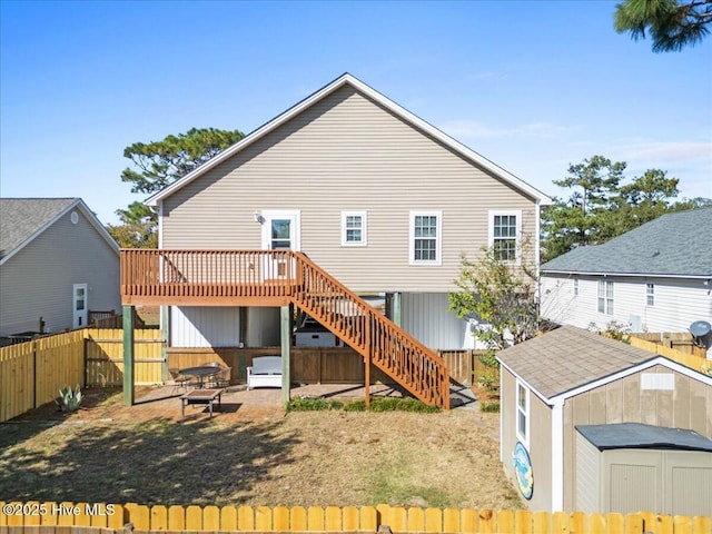 rear view of house with a deck and a storage unit