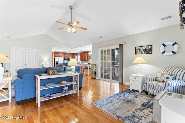 living room featuring hardwood / wood-style floors, vaulted ceiling, a healthy amount of sunlight, and ceiling fan