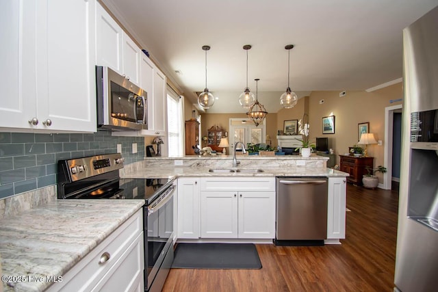 kitchen with stainless steel appliances, kitchen peninsula, sink, and white cabinets