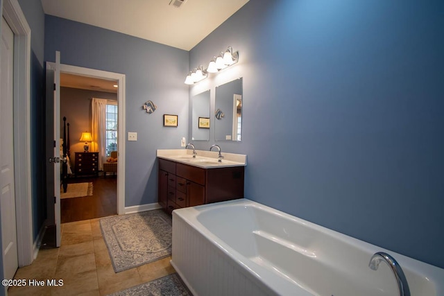 bathroom featuring tile patterned flooring, vanity, and a bath