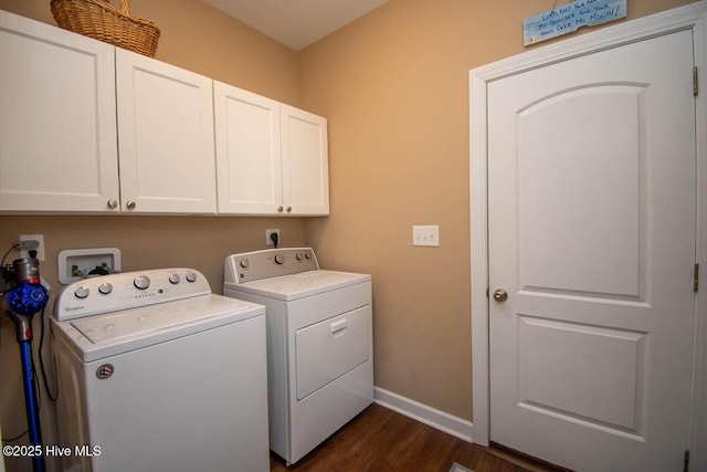 washroom with dark hardwood / wood-style flooring, washing machine and dryer, and cabinets