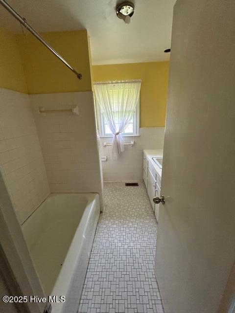 2030 US Highway 17, Merry Hill, NC 27957 - full bathroom featuring tile walls, shower / tub combination, a wainscoted wall, and a sink